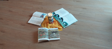 Kinderbibel auf dem Fußboden um eine Kerze